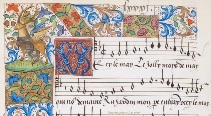 Illuminated medieval manuscript page with ornate floral borders, a deer on a hill, an illuminated initial V, and chant notation with Latin text on a five-line staff.